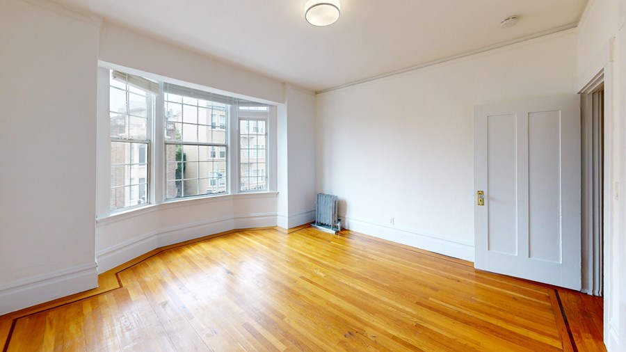 A room with a wooden floor and a window.